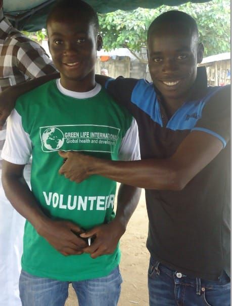Two smiling young volunteers, one in a volunteer T-shirt